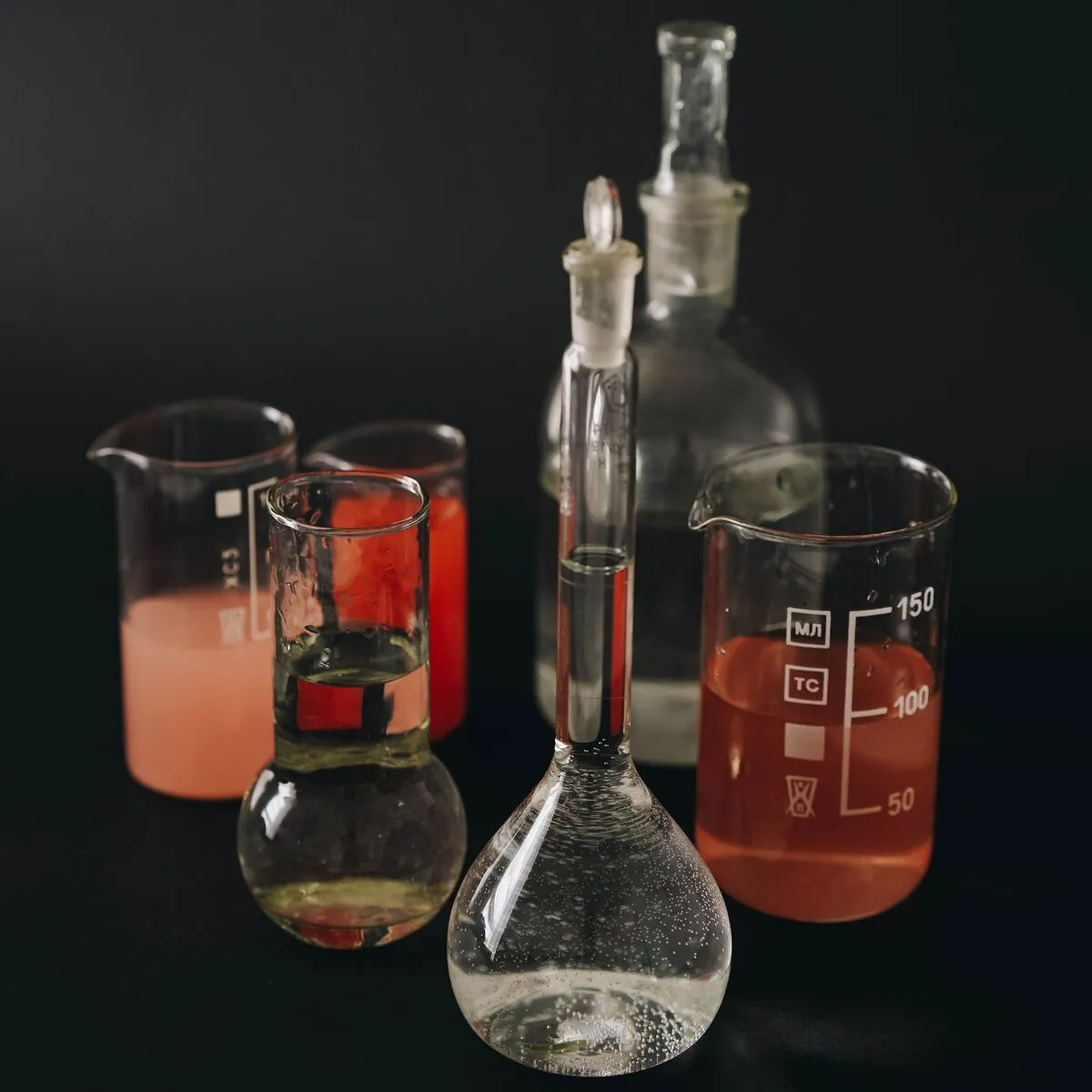 Vidrarias de laboratório com líquidos coloridos, representando a resistência do polipropileno a produtos químicos.