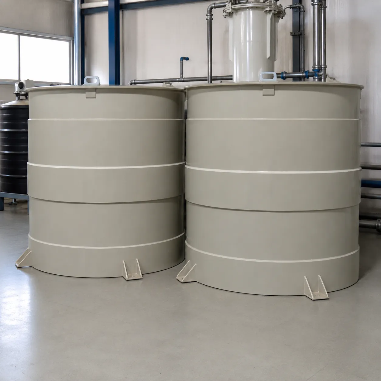 Dois tanques cilíndricos bege para armazenamento de bissulfito de sódio, instalados lado a lado em ambiente industrial.